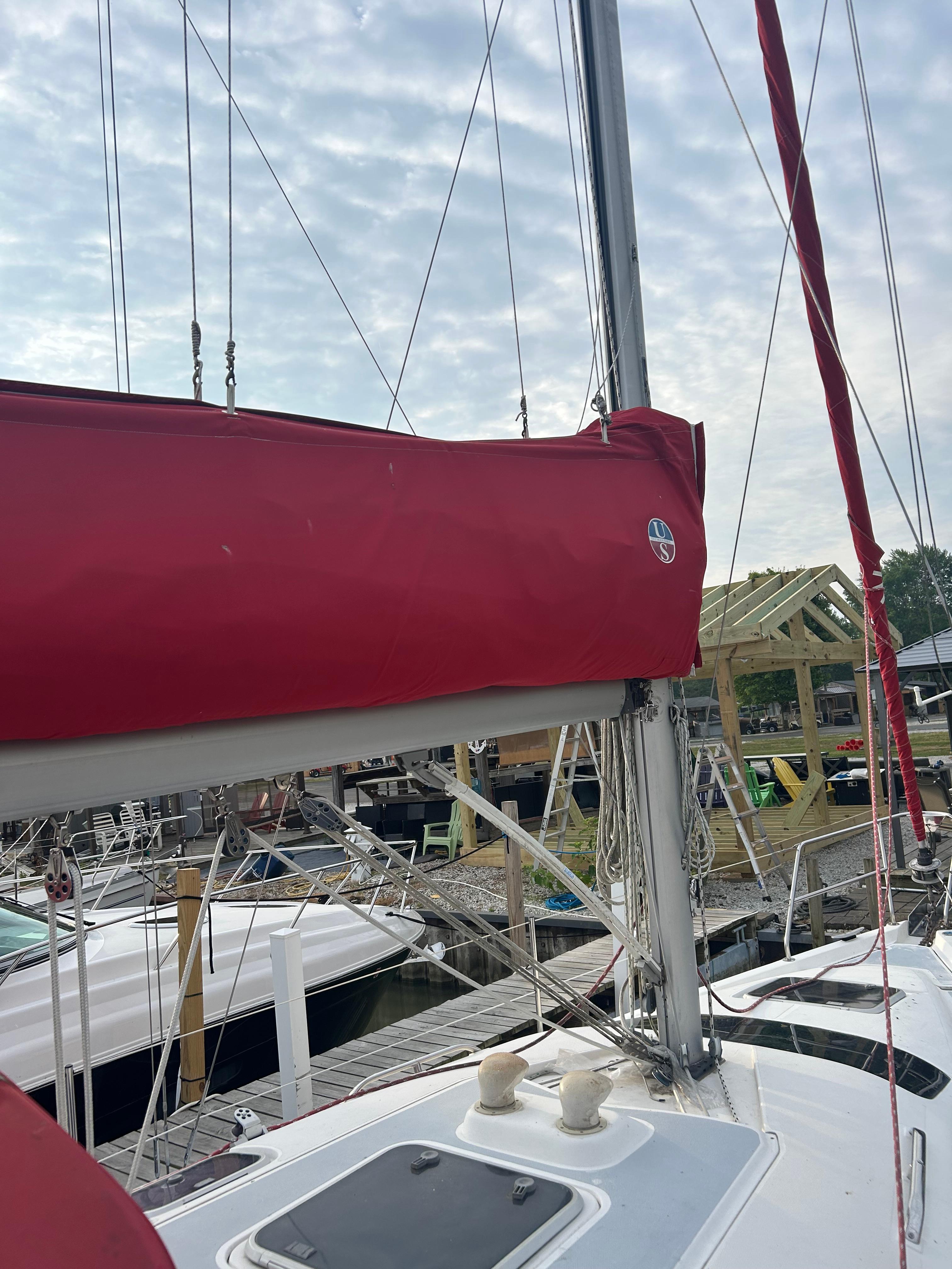 Sailboat Hunter 336, 1996 model, with red sail cover docked at marina.