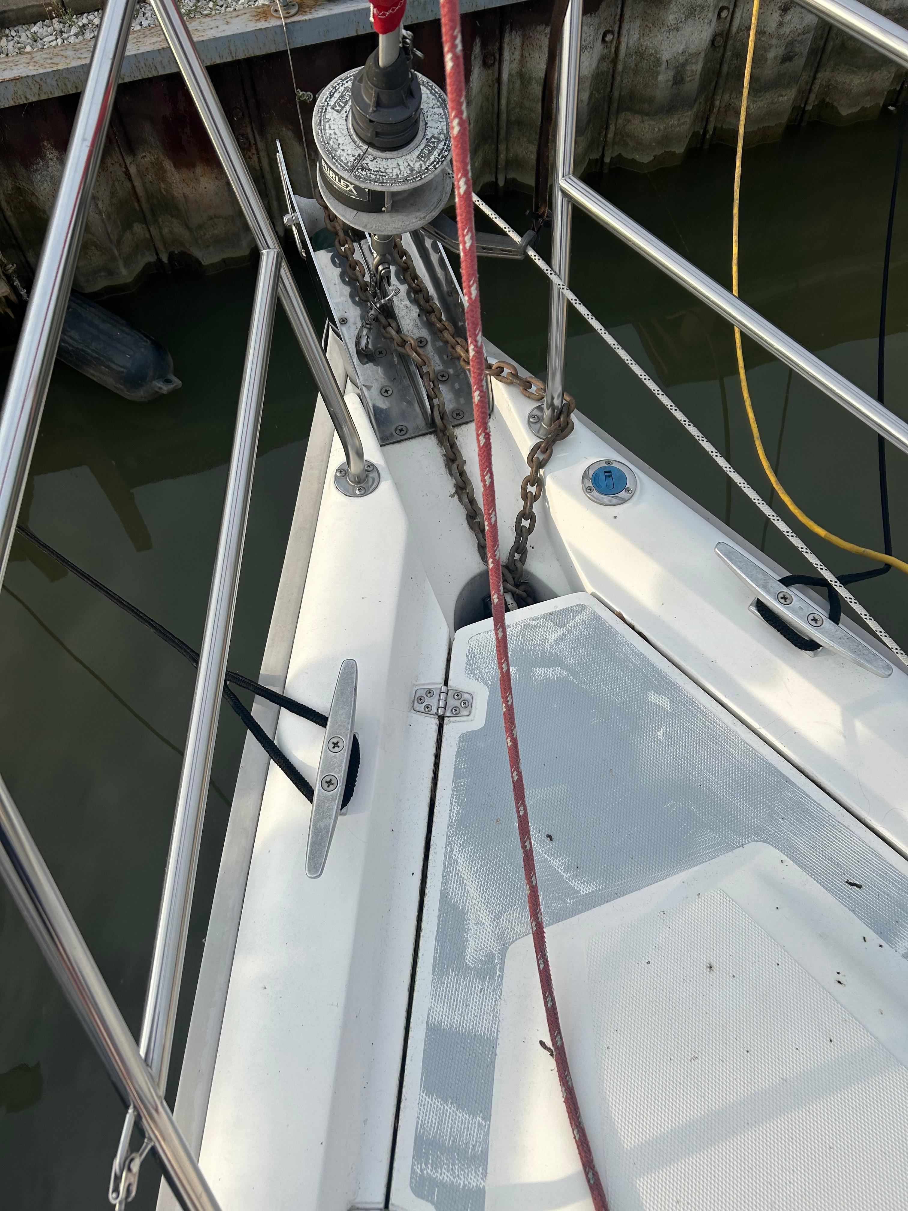 Bow of a 1996 Hunter 336 sailboat with anchor chain and deck fittings.