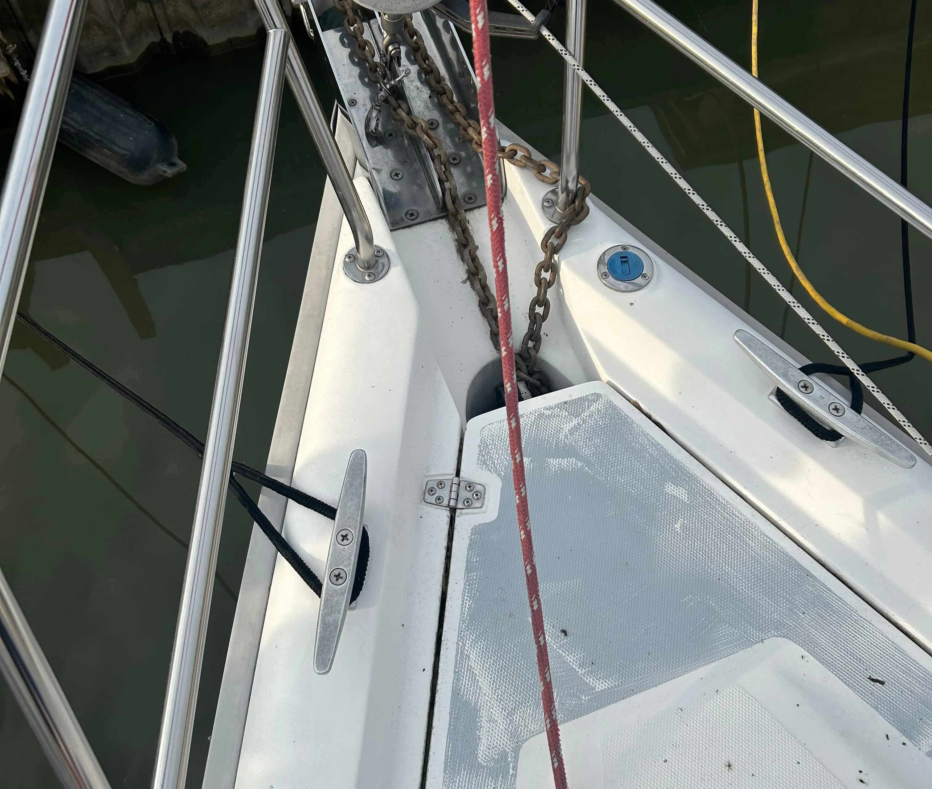 Bow of a 1996 Hunter 336 sailboat with anchor chain and deck fittings.