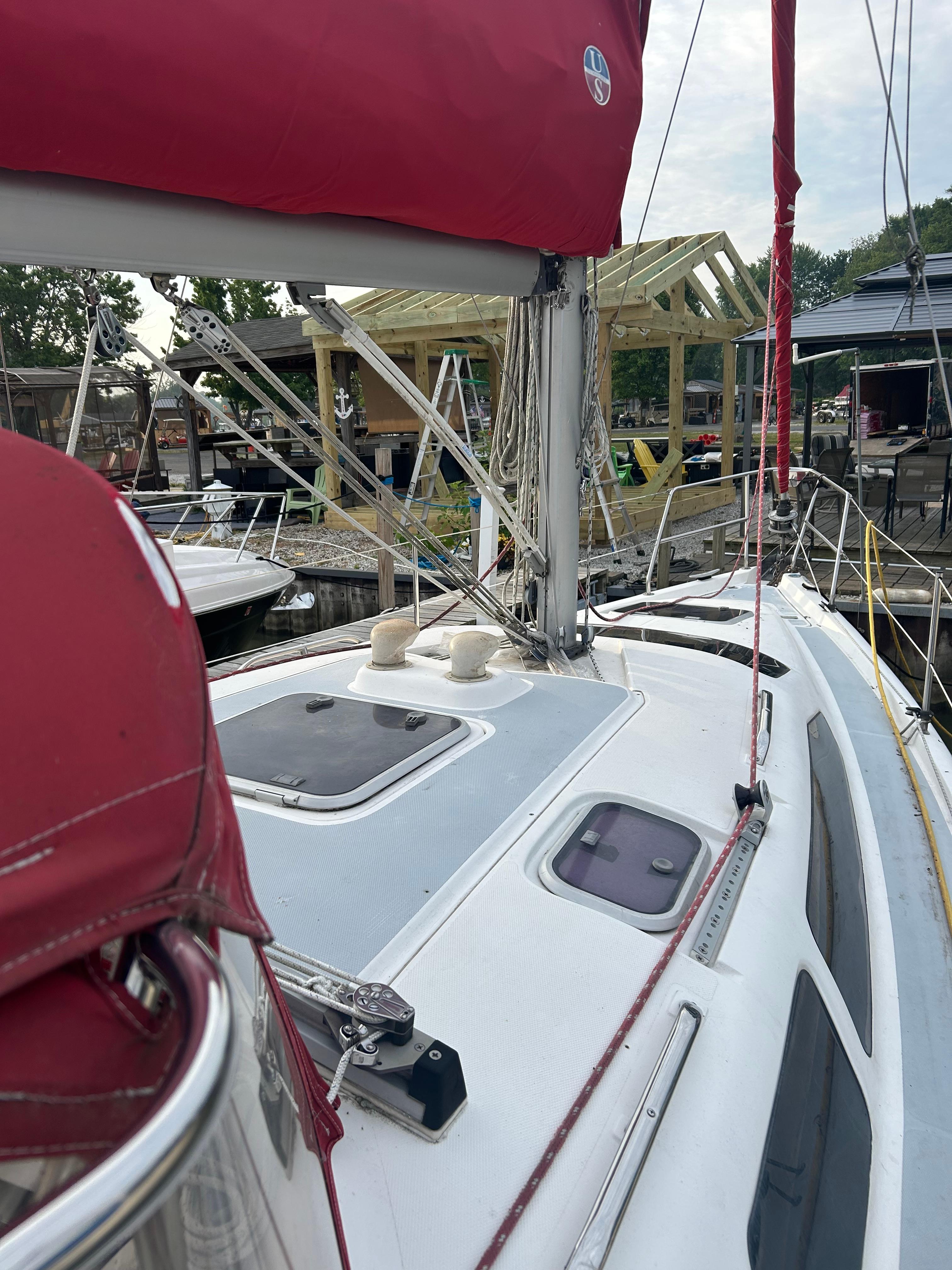 Sailboat deck view of 1996 Hunter 336 with red sail cover at marina.