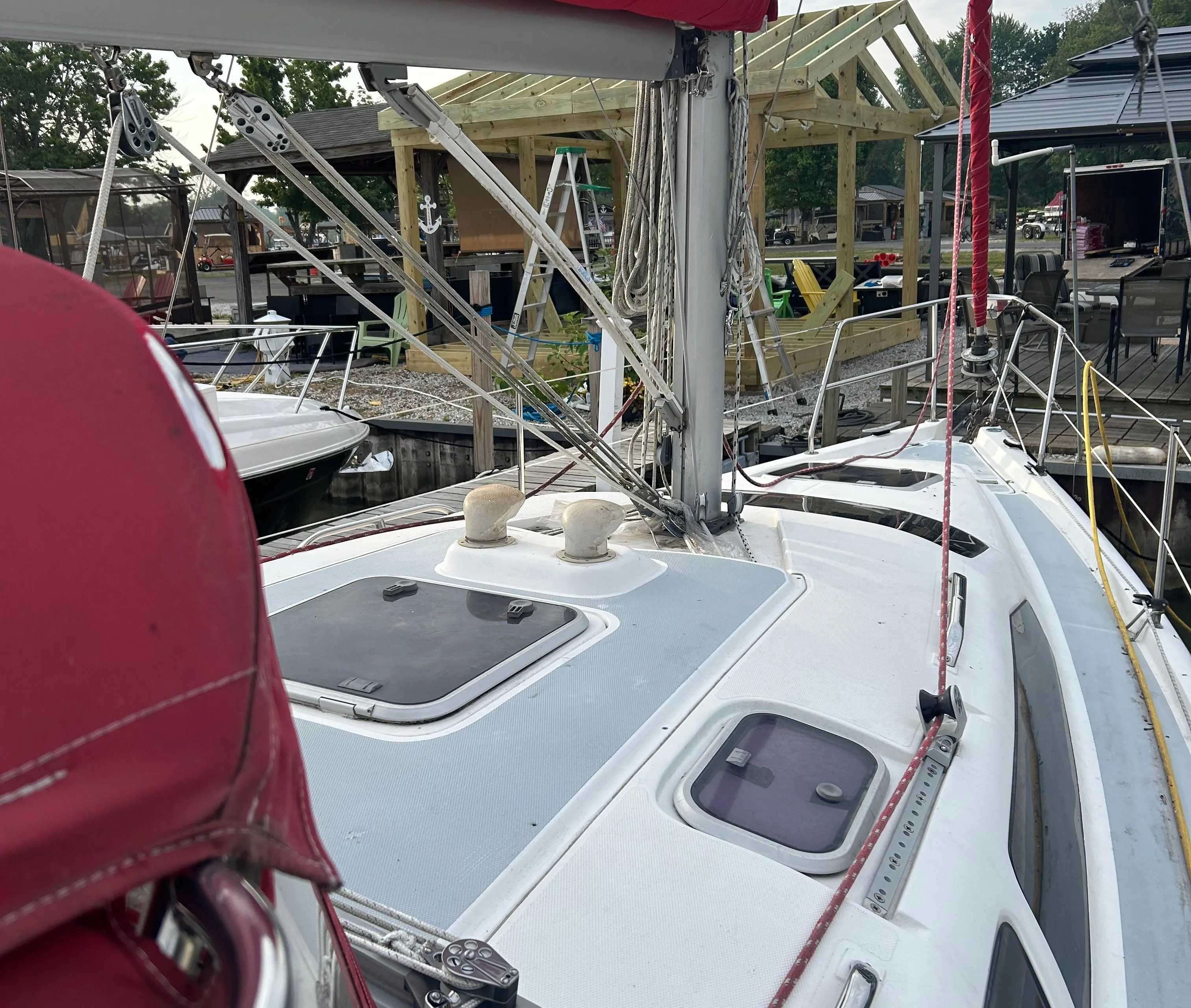 Sailboat deck view of 1996 Hunter 336 with red sail cover at marina.