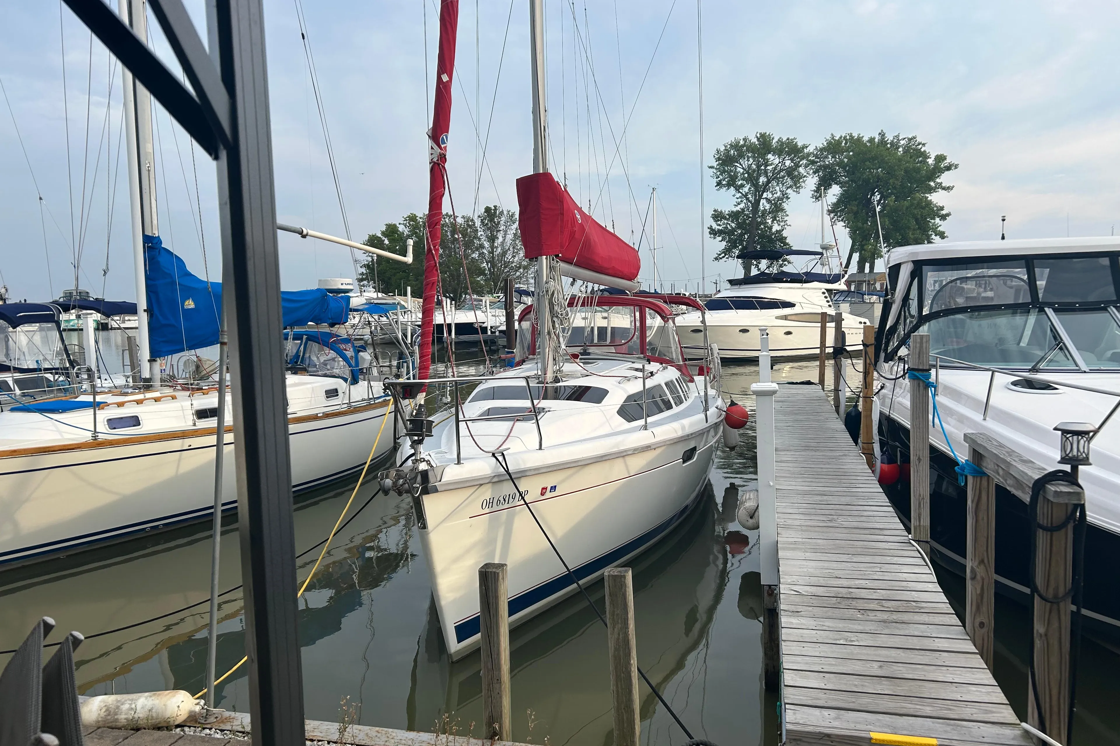Sailboat docked at marina, Hunter 336 model, 1996, with red sail cover.