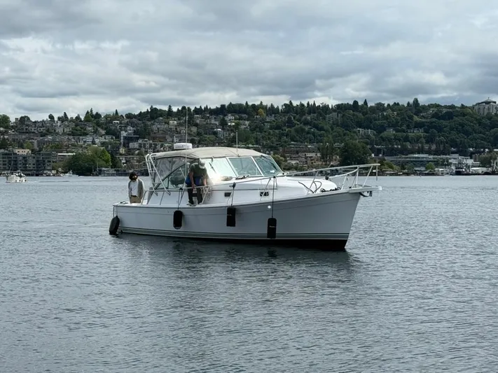 Christina Lee Yacht Photos Pics 2000 Mainship Pilot 34 boat on calm water with scenic shoreline background.