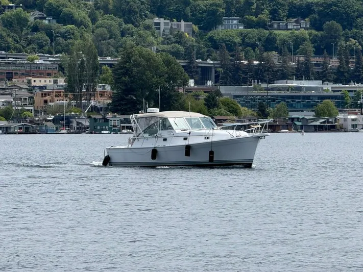 Christina Lee Yacht Photos Pics 2000 Mainship Pilot 34 cruising on a scenic lake with lush green shoreline.