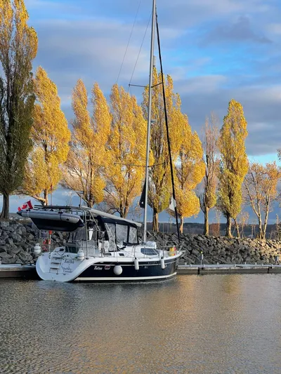 Talisa Yacht Photos Pics Sailboat Hunter 45cc (2006) docked by autumn trees under a cloudy sky.