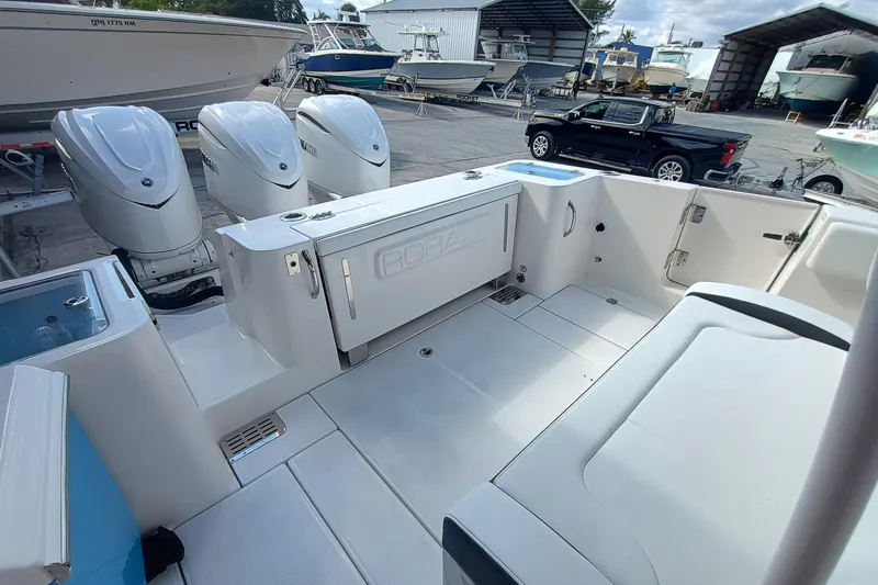 360-105 Yacht Photos Pics 2026 Robalo R360 Center Console boat with triple engines in a marina setting.