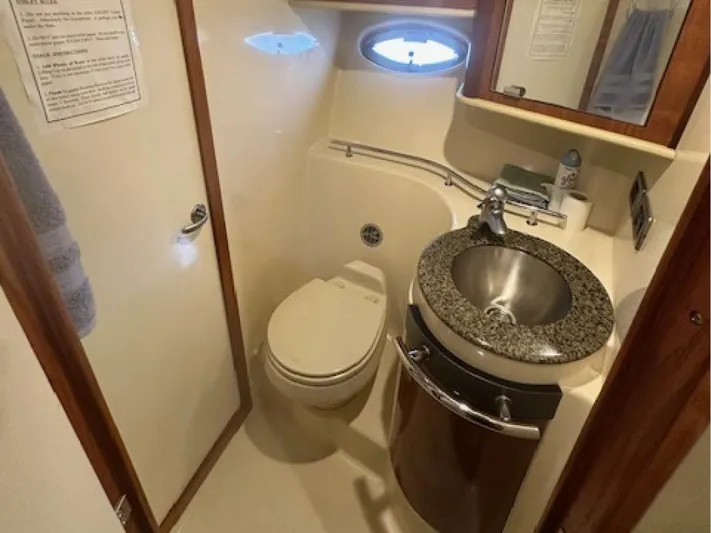  Yacht Photos Pics 2005 Sea Ray 390 Sundancer bathroom with sink, toilet, and porthole window.