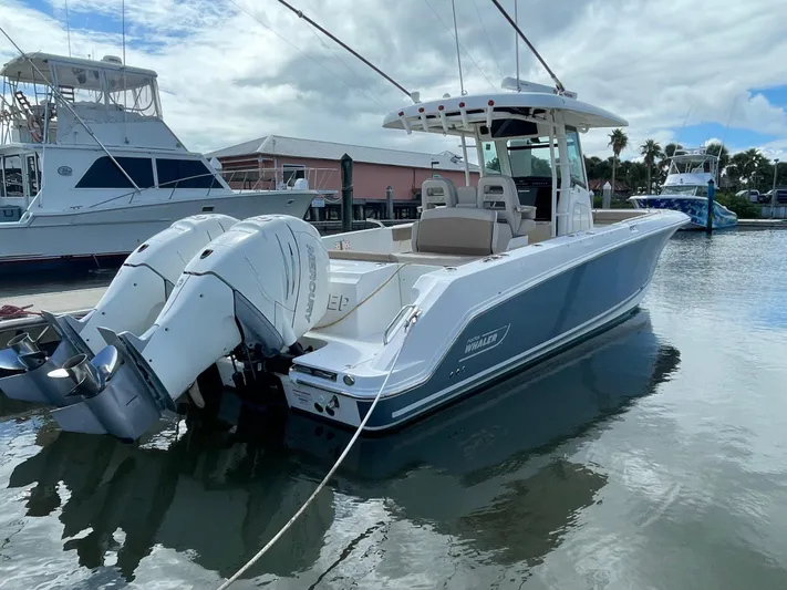  Yacht Photos Pics 2018 Boston Whaler 330 Outrage boat docked with twin engines, under cloudy sky.