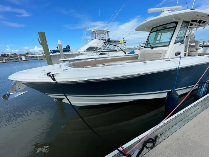  Yacht Photos Pics 2018 Boston Whaler 330 Outrage boat docked at marina under clear blue sky.