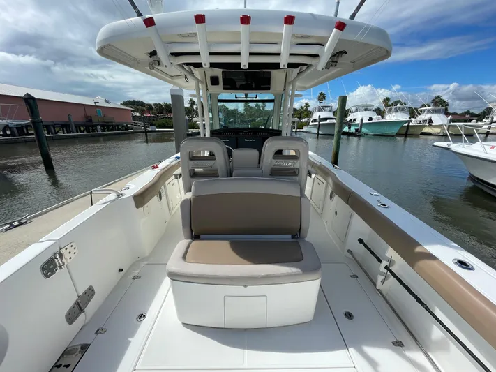  Yacht Photos Pics 2018 Boston Whaler 330 Outrage boat interior, featuring seating and helm, docked at marina.