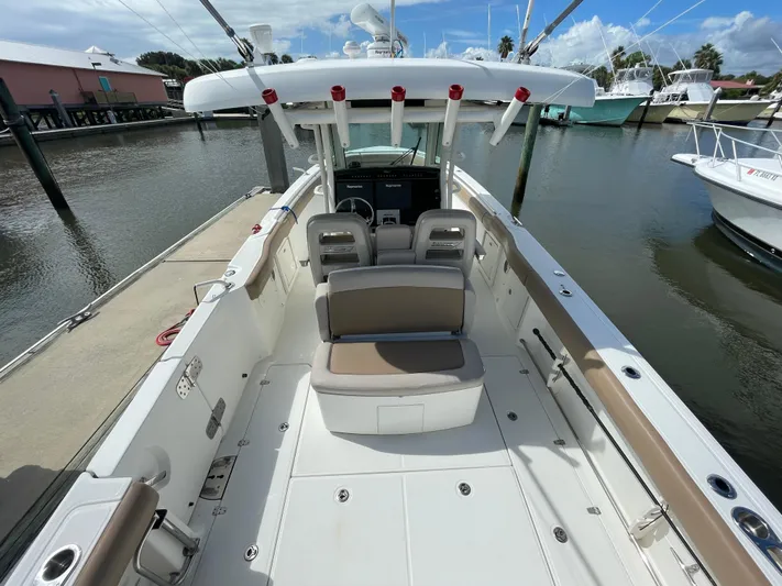  Yacht Photos Pics 2018 Boston Whaler 330 Outrage boat interior at marina, showcasing seating and helm.