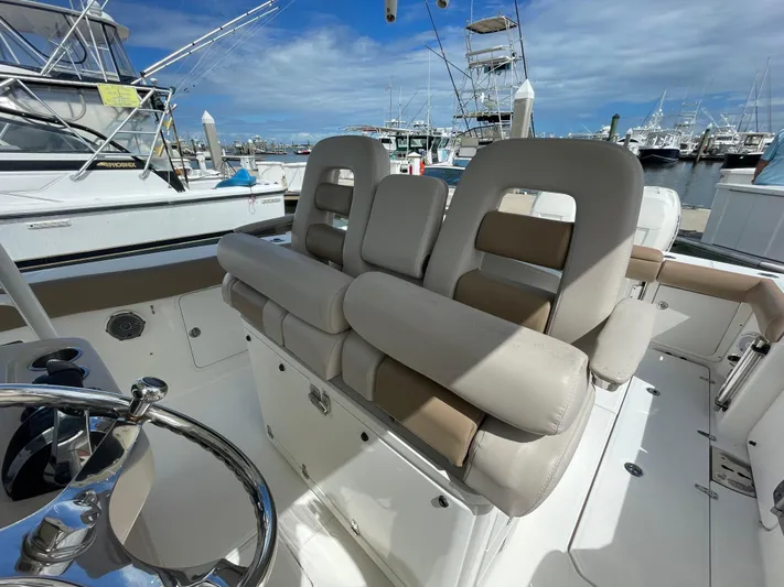  Yacht Photos Pics 2018 Boston Whaler 330 Outrage boat interior with cushioned seating at marina.