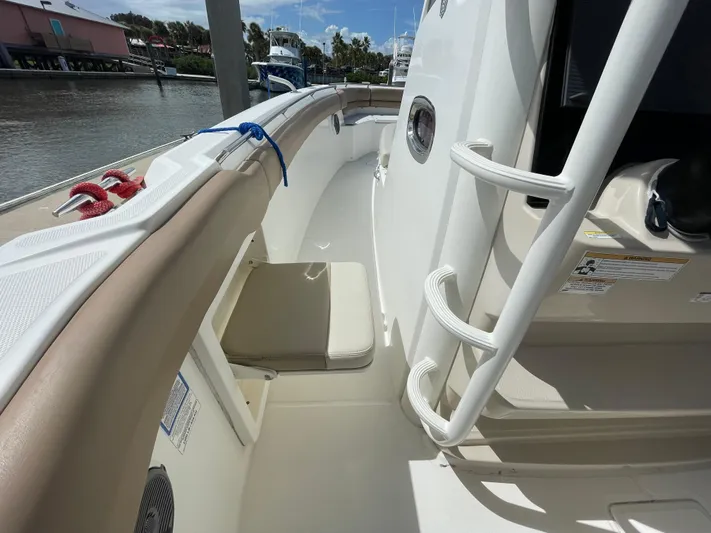  Yacht Photos Pics 2018 Boston Whaler 330 Outrage boat deck with seating and railing, docked by the water.