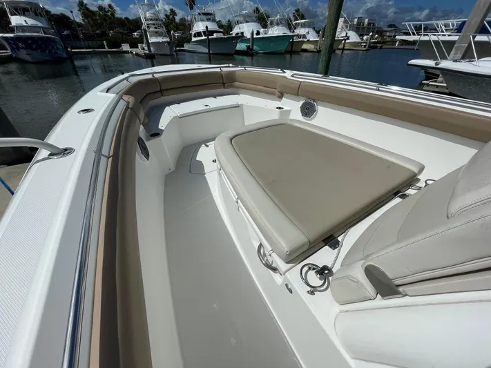  Yacht Photos Pics 2018 Boston Whaler 330 Outrage boat interior with cushioned seating in marina.