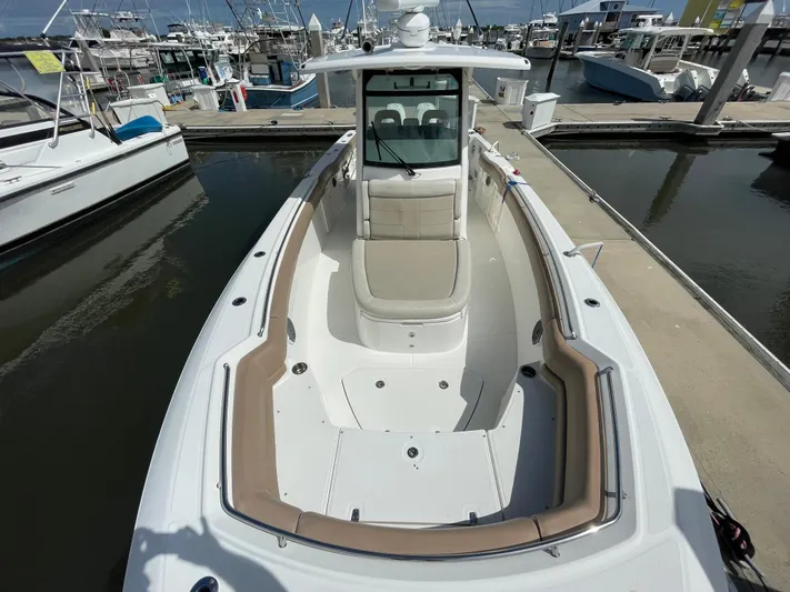  Yacht Photos Pics 2018 Boston Whaler 330 Outrage boat docked at marina, showcasing spacious deck and seating.