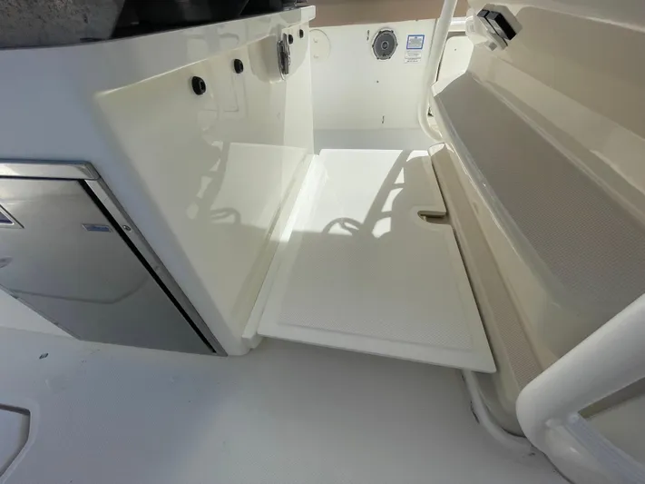  Yacht Photos Pics 2018 Boston Whaler 330 Outrage interior with fold-out step and storage compartment.