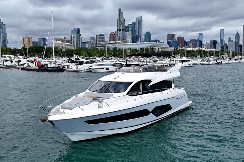 Yacht Photos Pics 2019 Sunseeker Manhattan 66 yacht cruising near city skyline and marina.