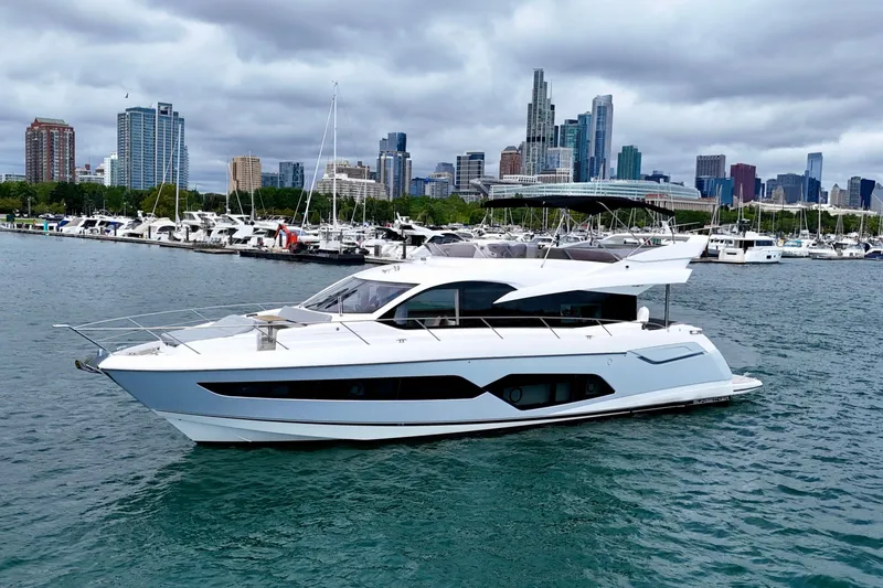  Yacht Photos Pics 2019 Sunseeker Manhattan 66 yacht cruising near city skyline and marina.