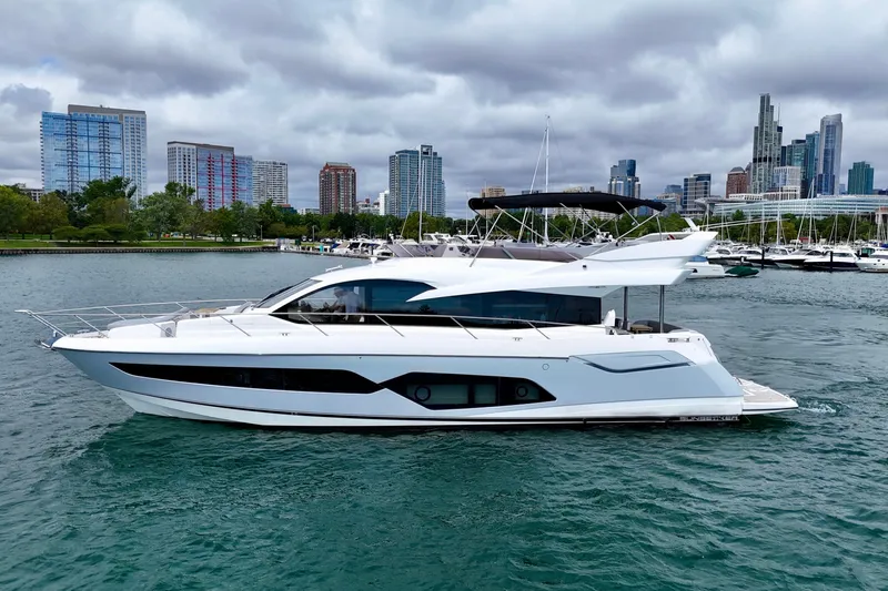  Yacht Photos Pics 2019 Sunseeker Manhattan 66 yacht cruising near city skyline and marina.