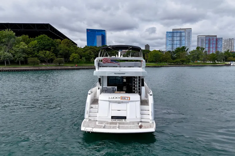  Yacht Photos Pics 2019 Sunseeker Manhattan 66 yacht on water, city skyline and trees in background.