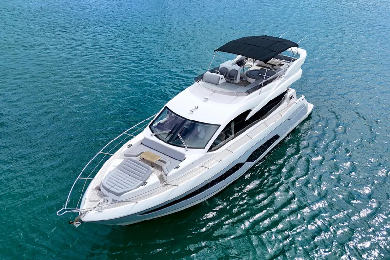  Yacht Photos Pics 2019 Sunseeker Manhattan 66 yacht cruising on clear blue water.