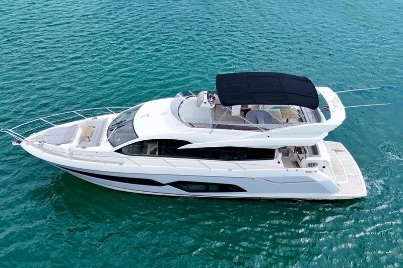  Yacht Photos Pics 2019 Sunseeker Manhattan 66 yacht cruising on clear blue water.