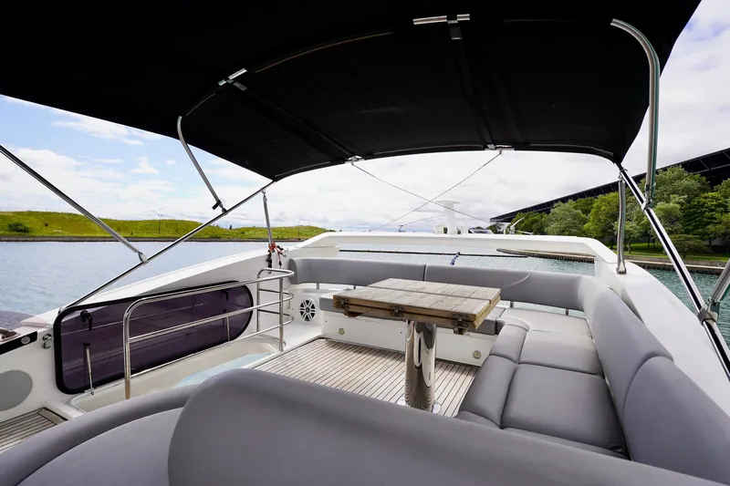  Yacht Photos Pics Luxurious 2019 Sunseeker Manhattan 66 yacht deck with seating and table, under canopy.