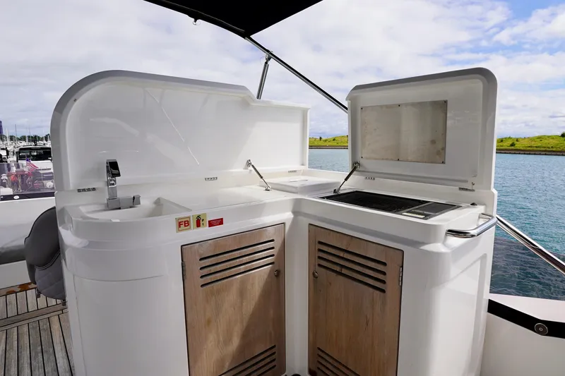  Yacht Photos Pics Outdoor kitchen on 2019 Sunseeker Manhattan 66 yacht with sink and grill, overlooking water.