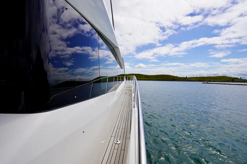  Yacht Photos Pics 2019 Sunseeker Manhattan 66 yacht on serene water with scenic sky reflection.