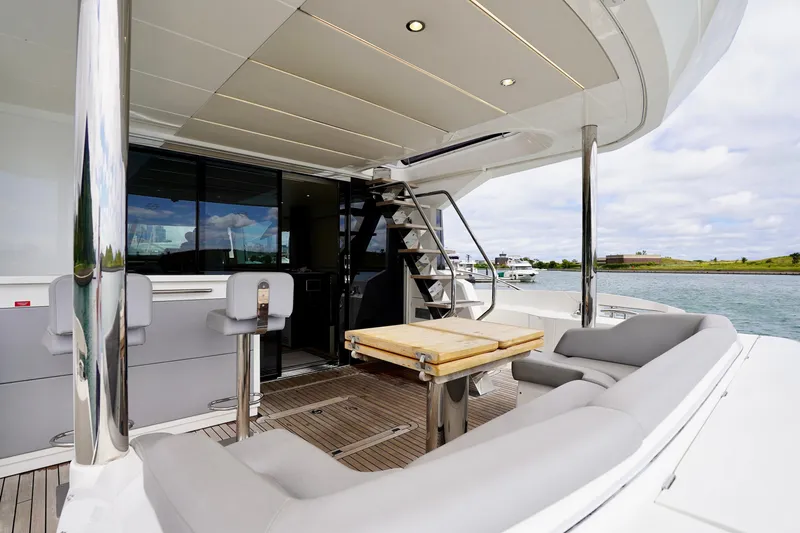  Yacht Photos Pics Luxurious 2019 Sunseeker Manhattan 66 yacht deck with seating and table, overlooking serene waters.