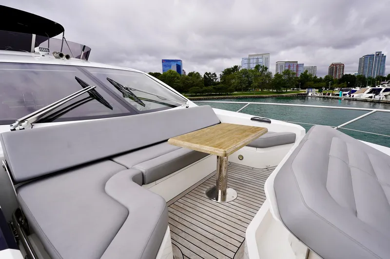 Yacht Photos Pics Luxurious 2019 Sunseeker Manhattan 66 yacht with elegant seating and table, docked near cityscape.