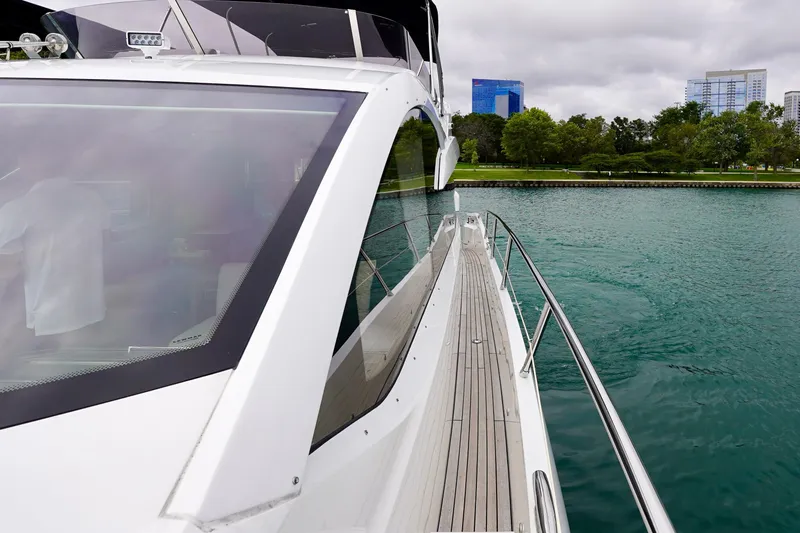  Yacht Photos Pics 2019 Sunseeker Manhattan 66 yacht on calm water near a cityscape.
