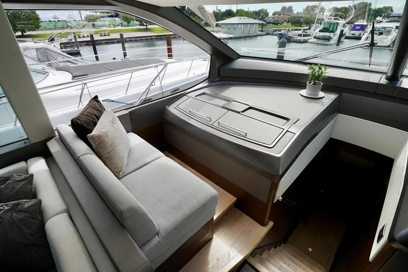 Yacht Photos Pics Luxurious interior of 2019 Sunseeker Manhattan 66 yacht with plush seating and scenic marina view.