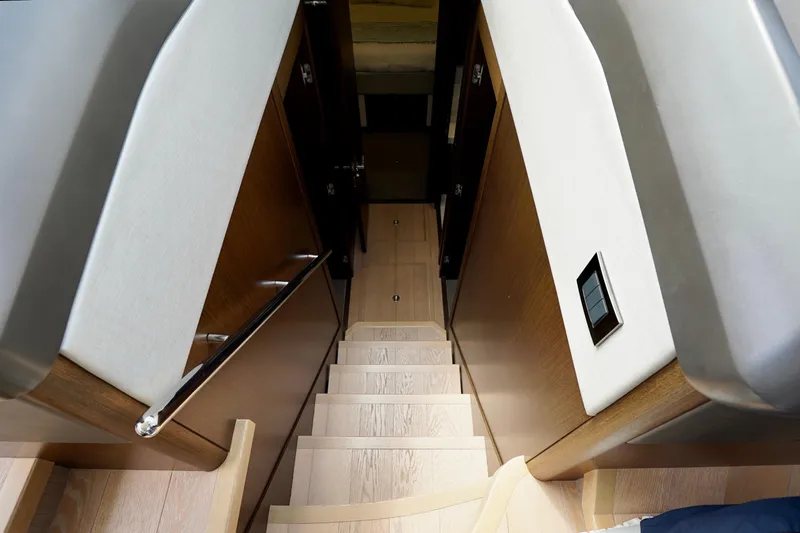  Yacht Photos Pics Staircase inside 2019 Sunseeker Manhattan 66 yacht, featuring sleek wood and modern design.