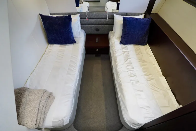  Yacht Photos Pics Twin cabin interior of 2019 Sunseeker Manhattan 66 yacht with blue pillows.