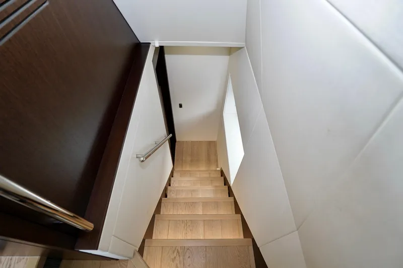  Yacht Photos Pics Staircase inside 2019 Sunseeker Manhattan 66 yacht, featuring sleek wood and modern design.