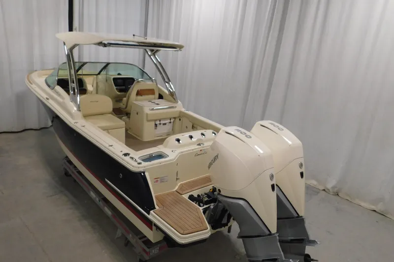  Yacht Photos Pics 2023 Chris-Craft Calypso 28 boat with dual Mercury engines in a showroom.