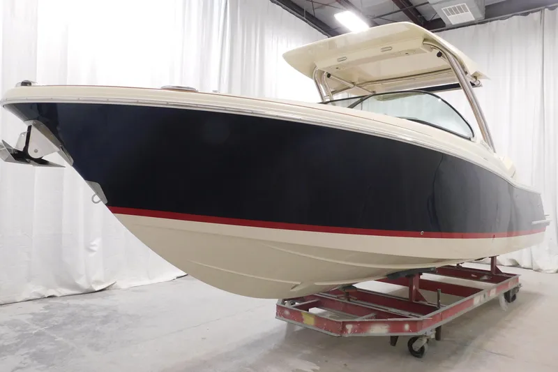  Yacht Photos Pics 2023 Chris-Craft Calypso 28 boat in showroom, featuring sleek design and elegant navy hull.