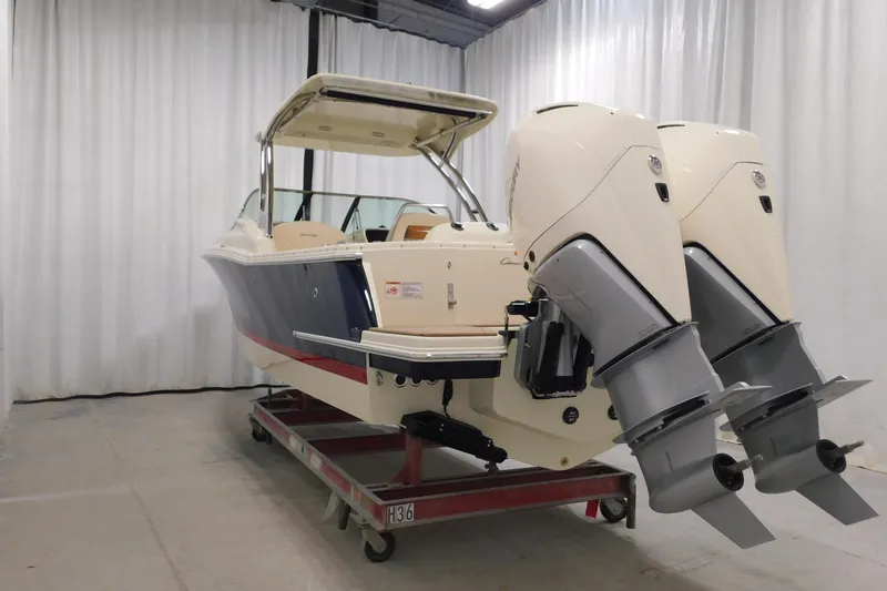  Yacht Photos Pics 2023 Chris-Craft Calypso 28 boat with dual outboard engines in a showroom.