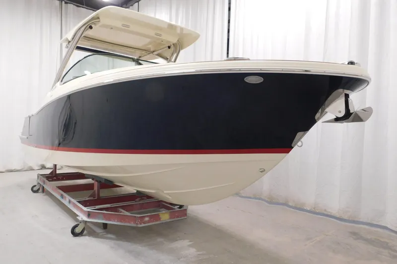  Yacht Photos Pics 2023 Chris-Craft Calypso 28 boat in showroom, featuring sleek design and elegant navy hull.