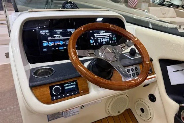  Yacht Photos Pics 2023 Chris-Craft Calypso 28 dashboard with wooden steering wheel and modern digital displays.