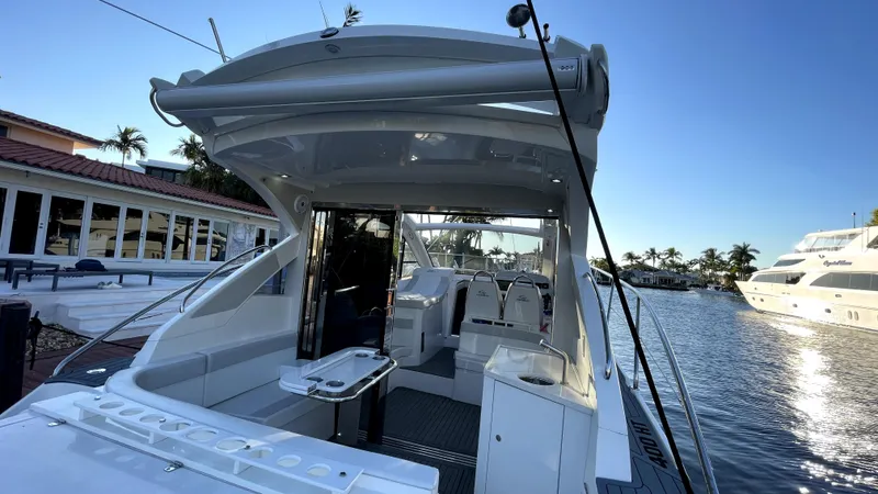  Yacht Photos Pics 2022 Evolve 400HT yacht docked by waterfront homes and palm trees.
