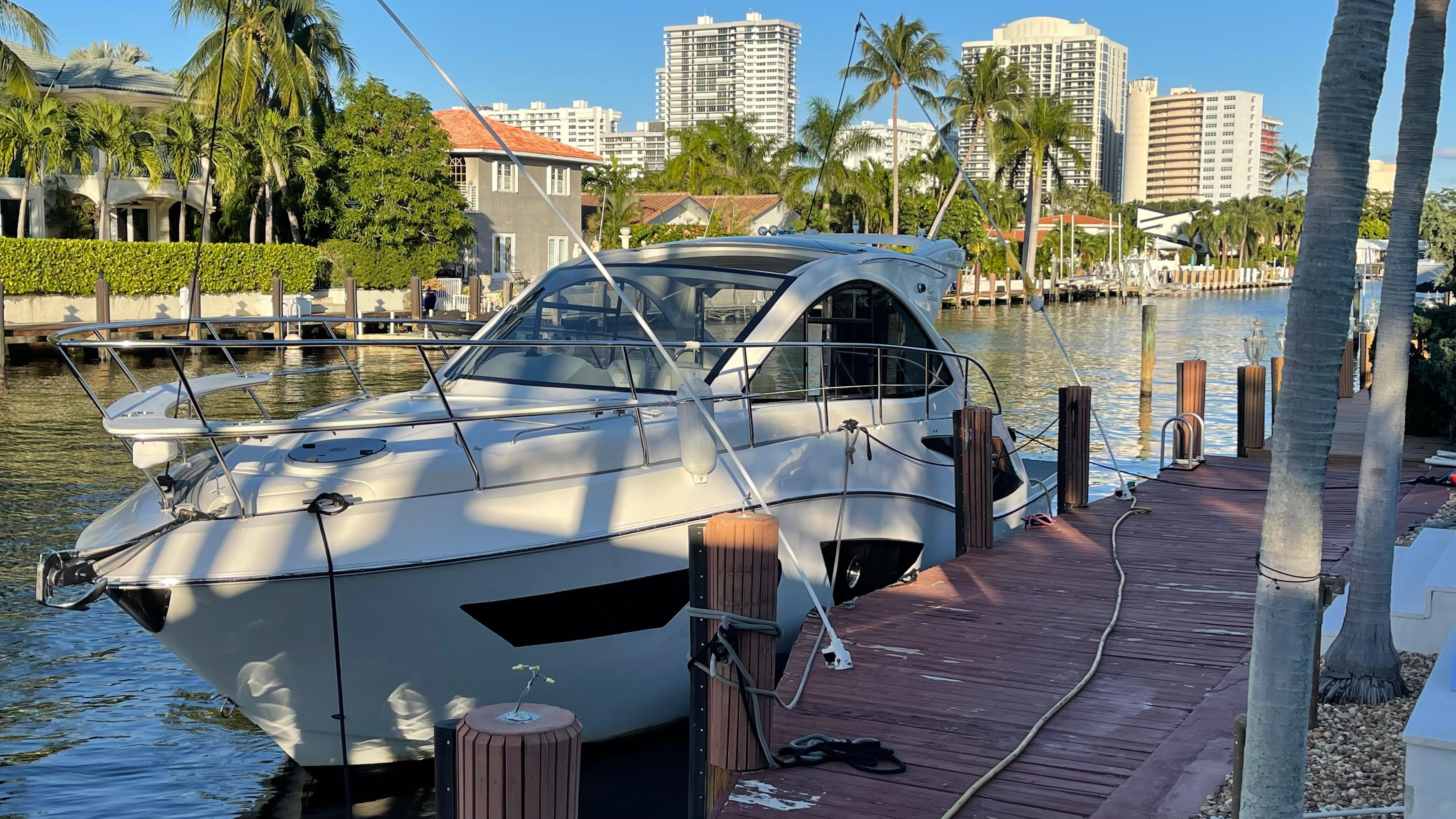 Luxury Evolve 400HT yacht docked by waterfront homes, 2022 model.