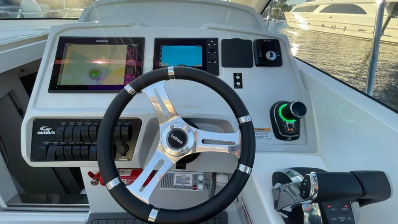  Yacht Photos Pics Evolve 400HT 2022 boat dashboard with steering wheel and navigation controls.