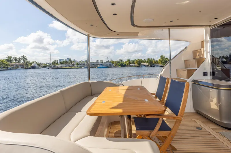 Her Way Yacht Photos Pics Luxurious 2023 Princess Y72 yacht deck with seating, table, and scenic waterfront view.