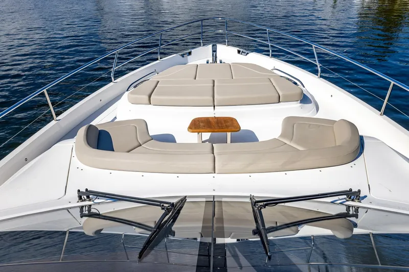 Her Way Yacht Photos Pics Luxurious 2023 Princess Y72 yacht deck with cushioned seating and table on calm water.