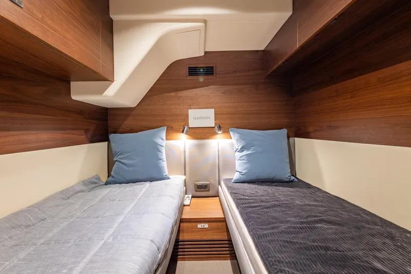 Her Way Yacht Photos Pics Luxurious twin cabin interior of 2023 Princess Y72 yacht with wooden finish and blue pillows.