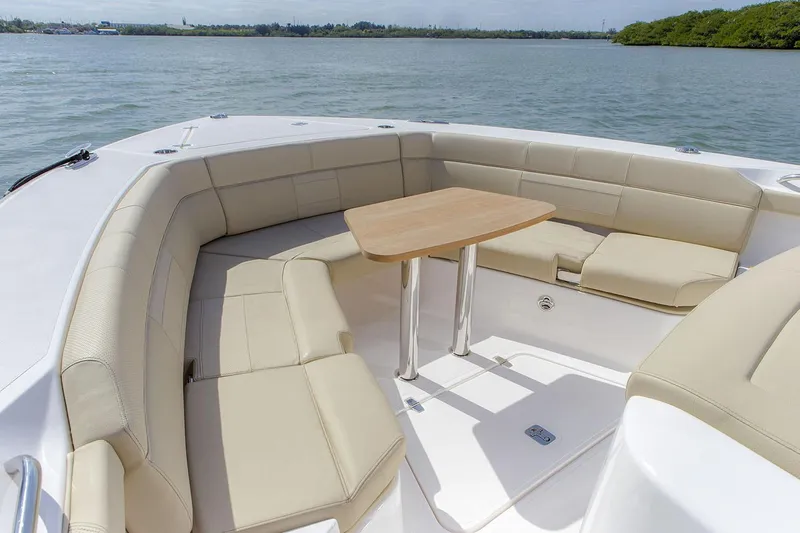 Yacht Photos Pics Manufacturer Provided Image: 2019 Pursuit S 408 Sport boat with beige seating and wooden table on water.