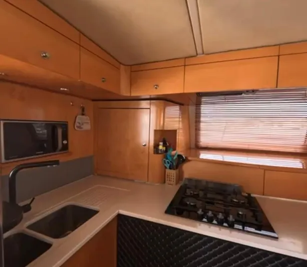 Kishta Yacht Photos Pics 2009 Fountaine Pajot Cumberland 46 yacht kitchen with wooden cabinetry and modern appliances.