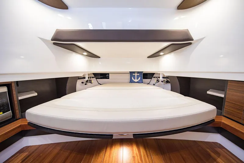  Yacht Photos Pics Manufacturer Provided Image: 2020 Pursuit S 368 Sport boat interior cabin with bed and wooden flooring.